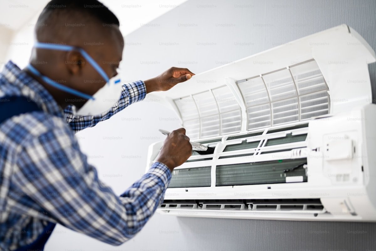 HVAC technician conducting seasonal air conditioning maintenance and air filtration inspection